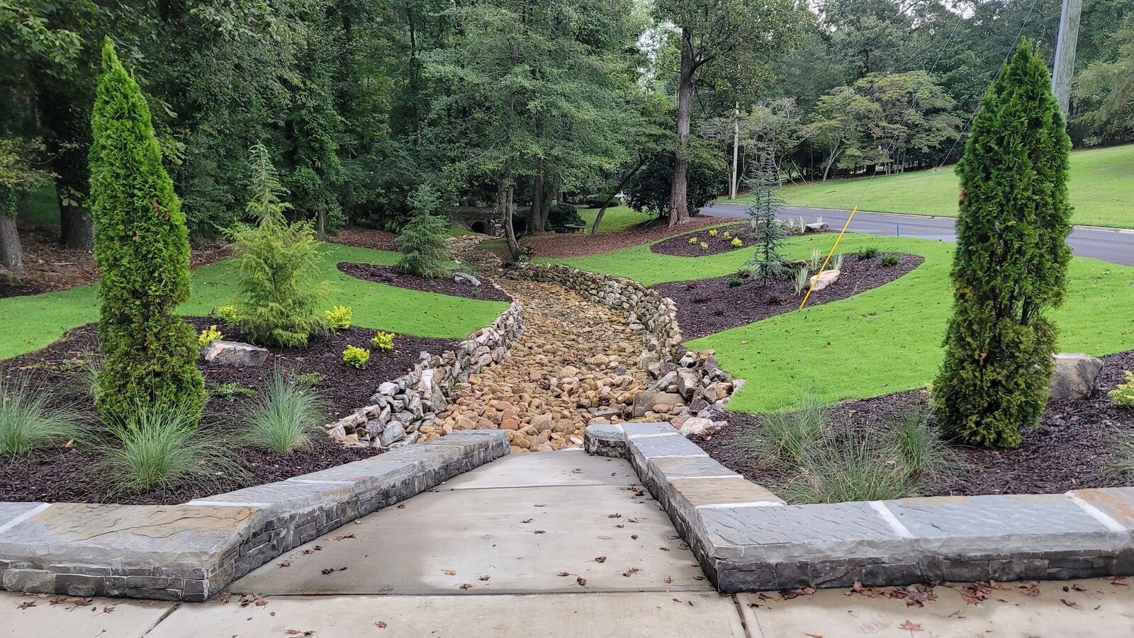 Curved garden beds with fresh plantings and stacked-stone borders